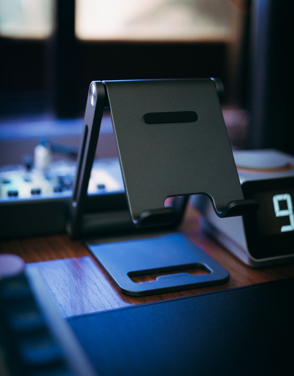 Adjustable metal tablet stand on a wooden desk
