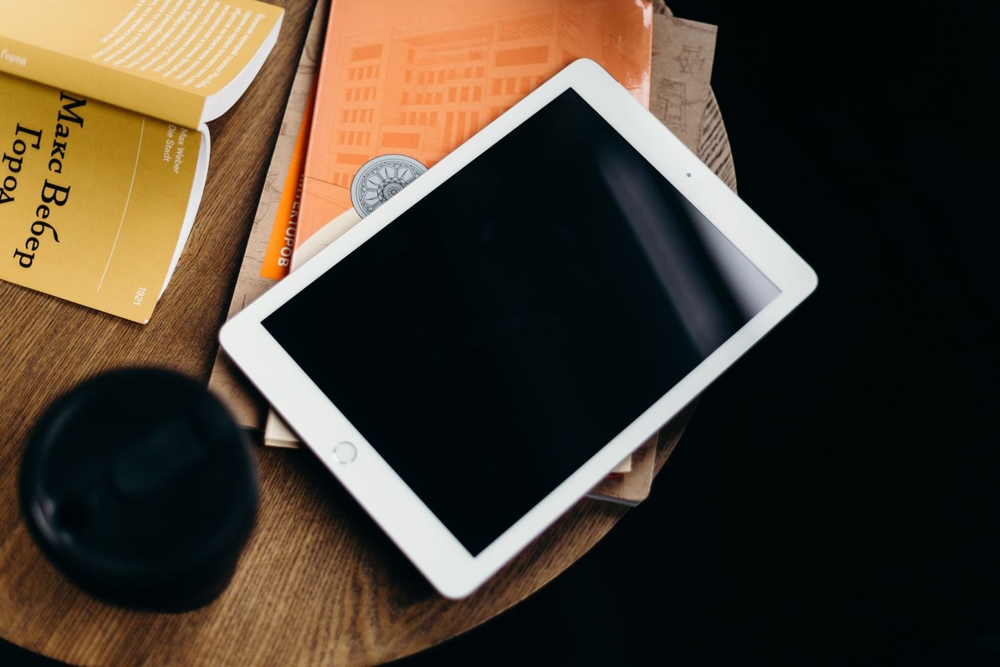 Tablet resting beside printed books