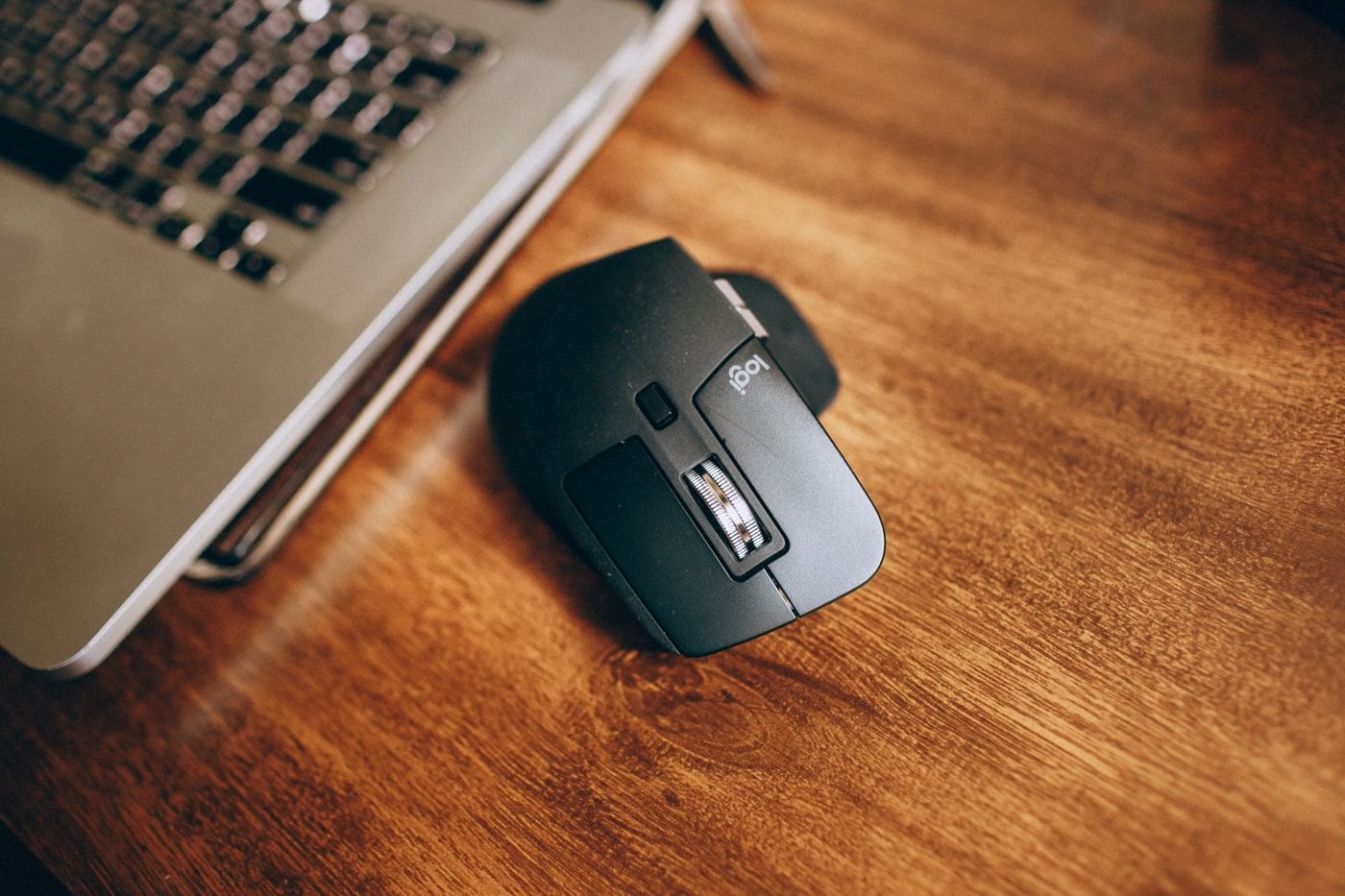 Compact wireless mouse beside a laptop