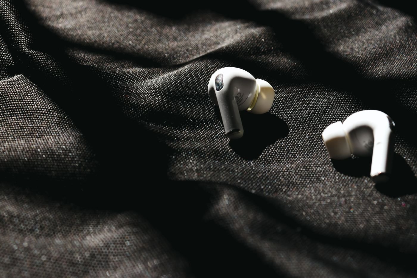 Wireless earbuds with silicone tips on dark fabric