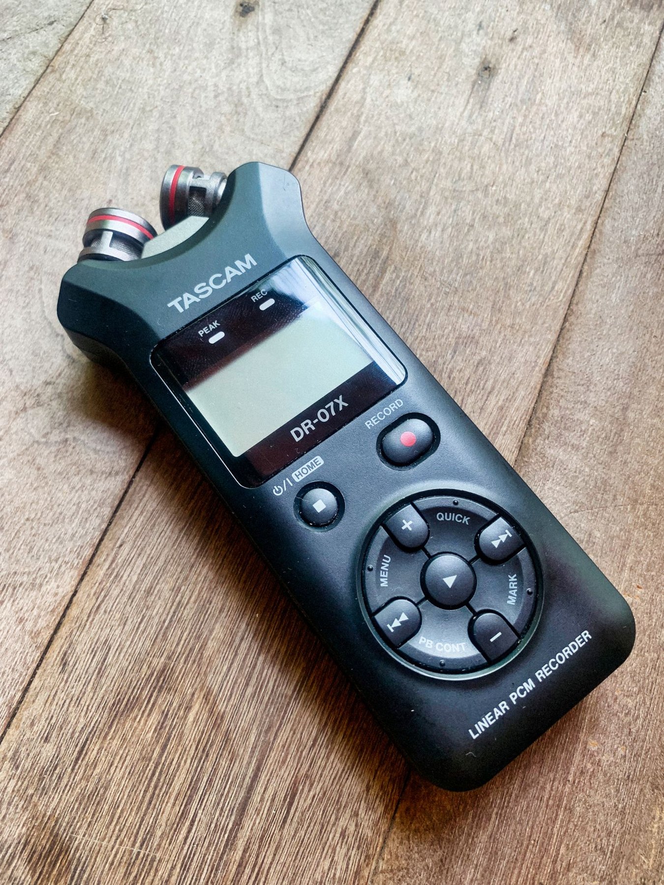 Portable handheld audio recorder on a wooden surface