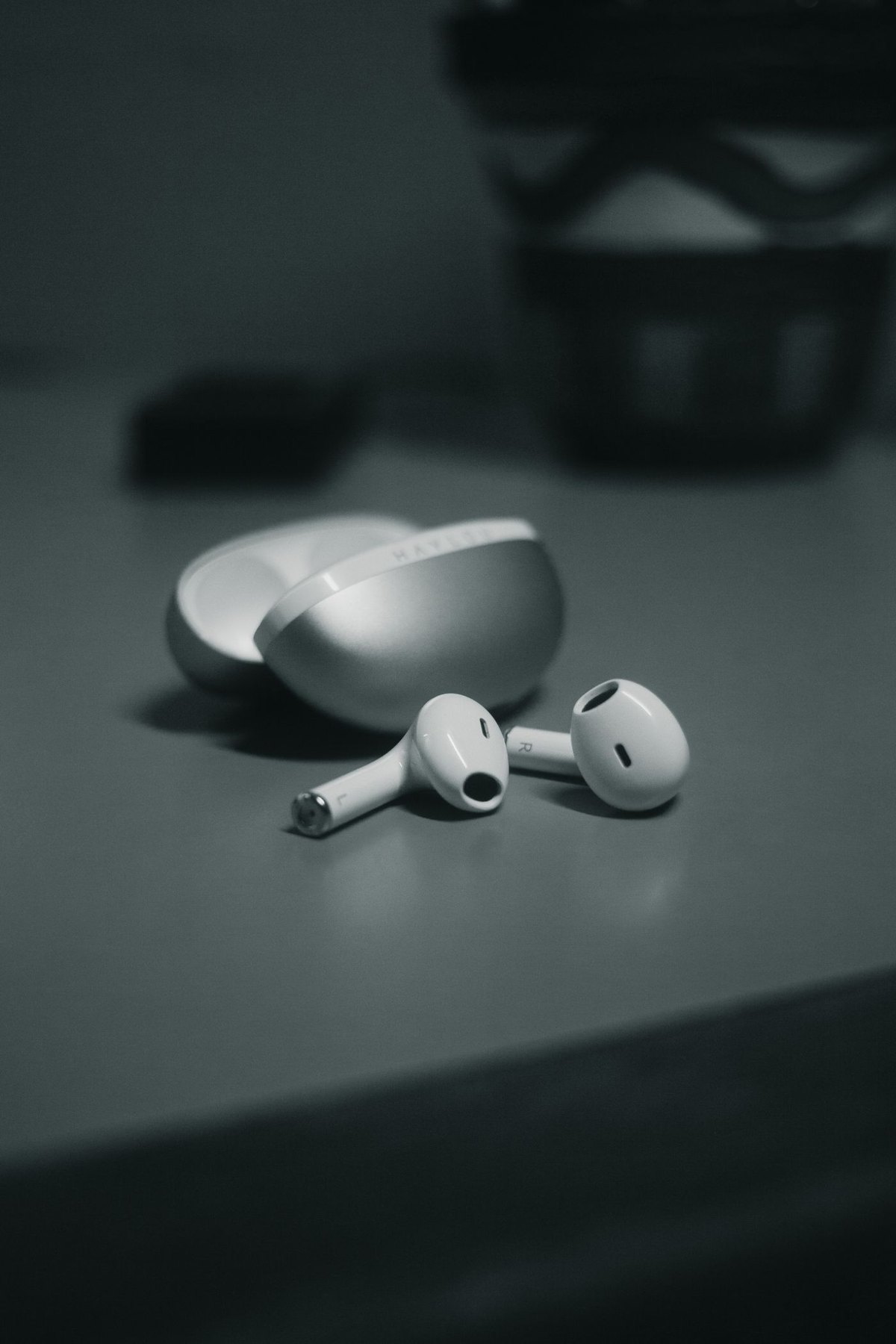 Wireless earbuds and open charging case on a desk