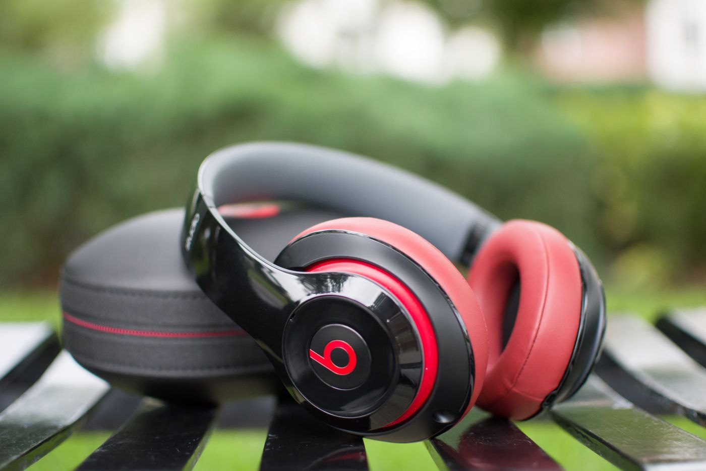 Over-ear headphones with padded ear cups beside a case