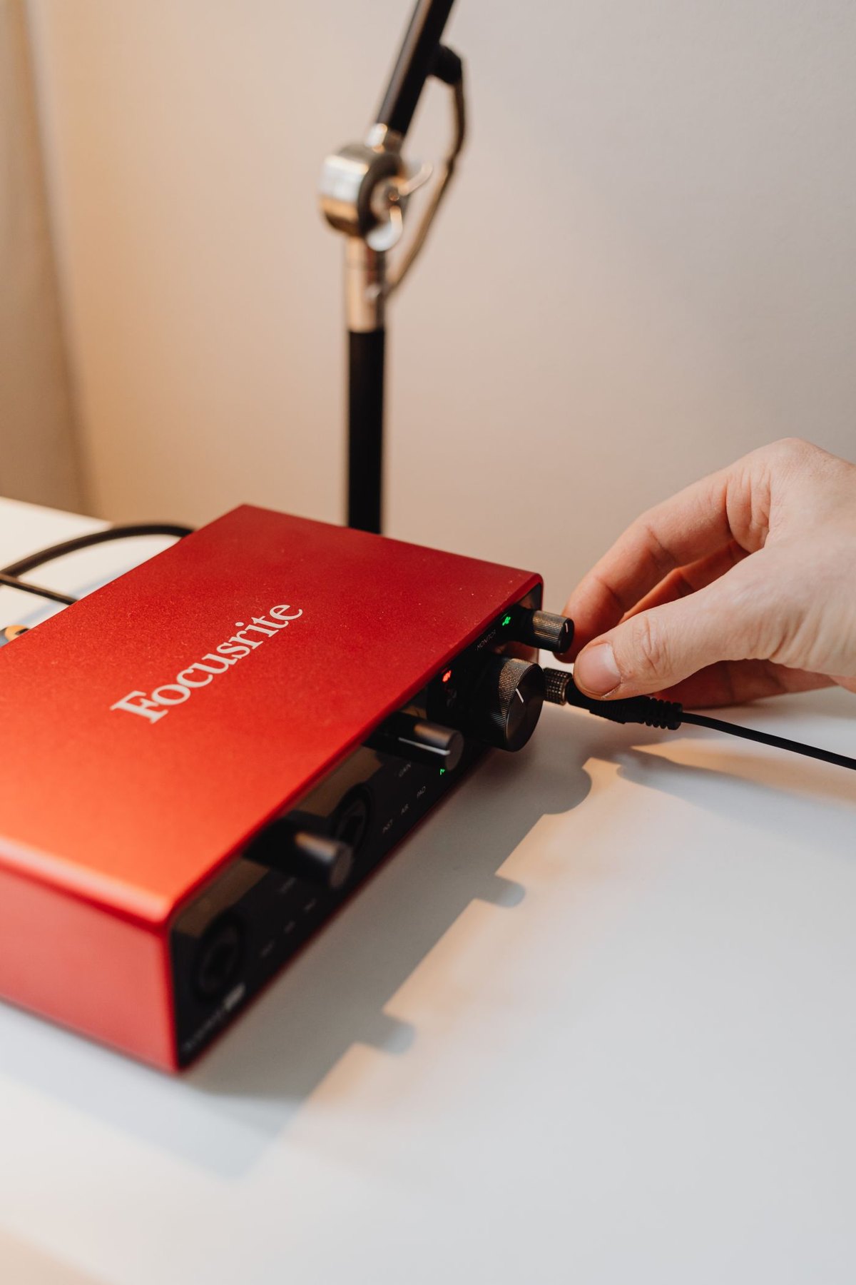 Hand connecting a cable to an audio interface