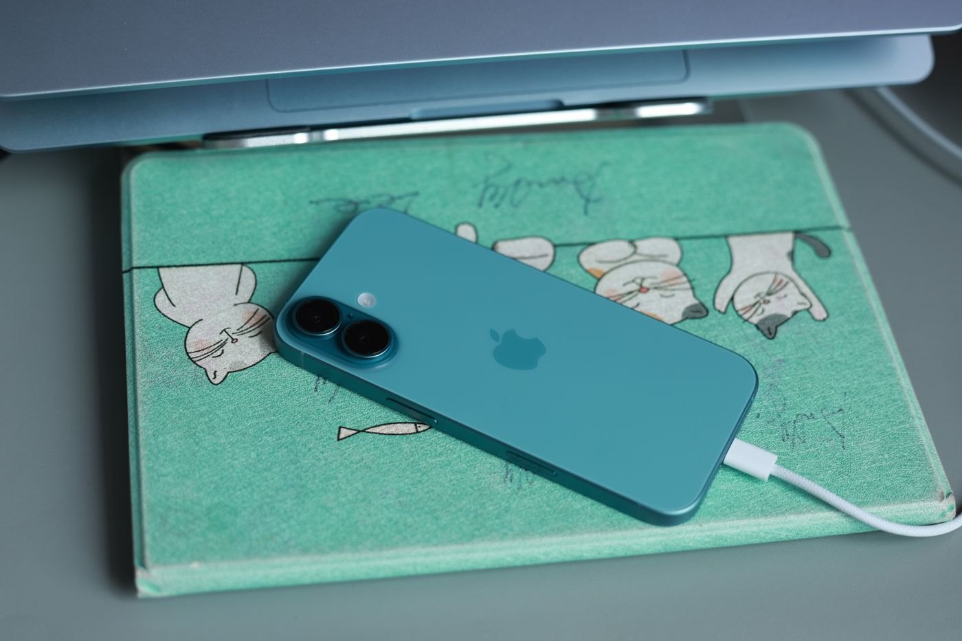 Phone connected to a charging cable on a desk mat