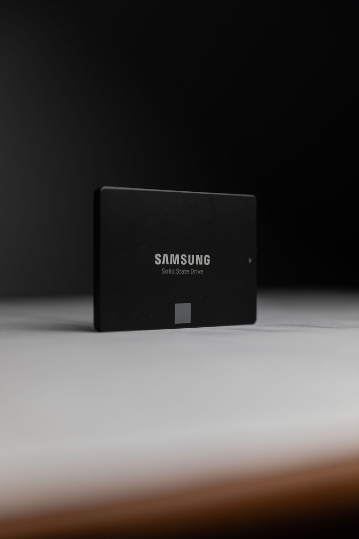 Black portable solid-state drive on a pale surface