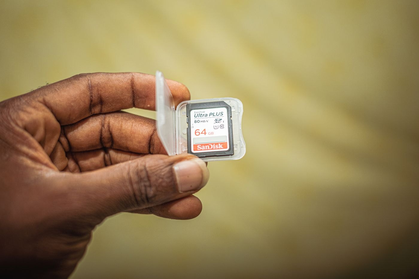 Hand holding a memory card inside a protective case