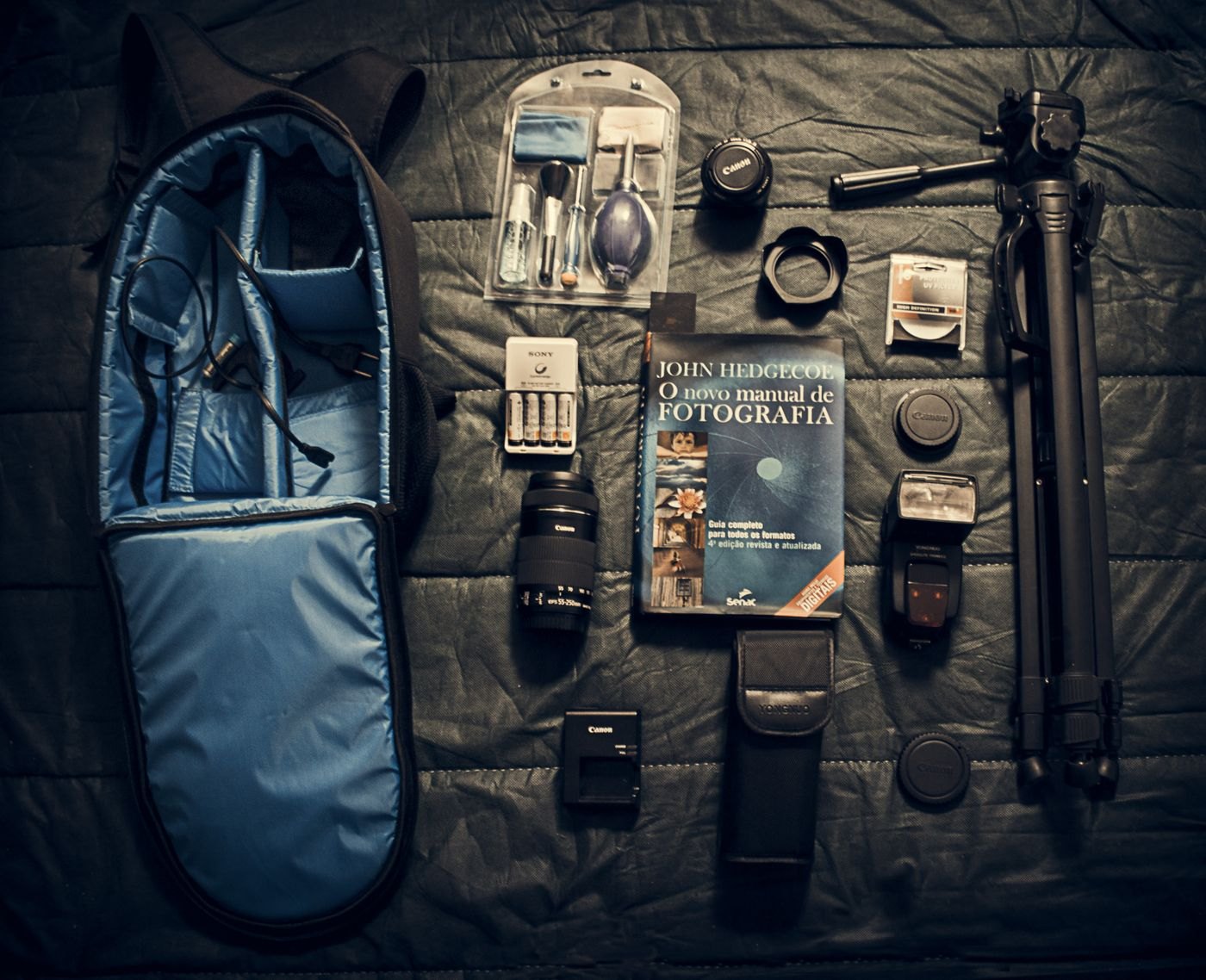 Camera accessories arranged beside an open backpack