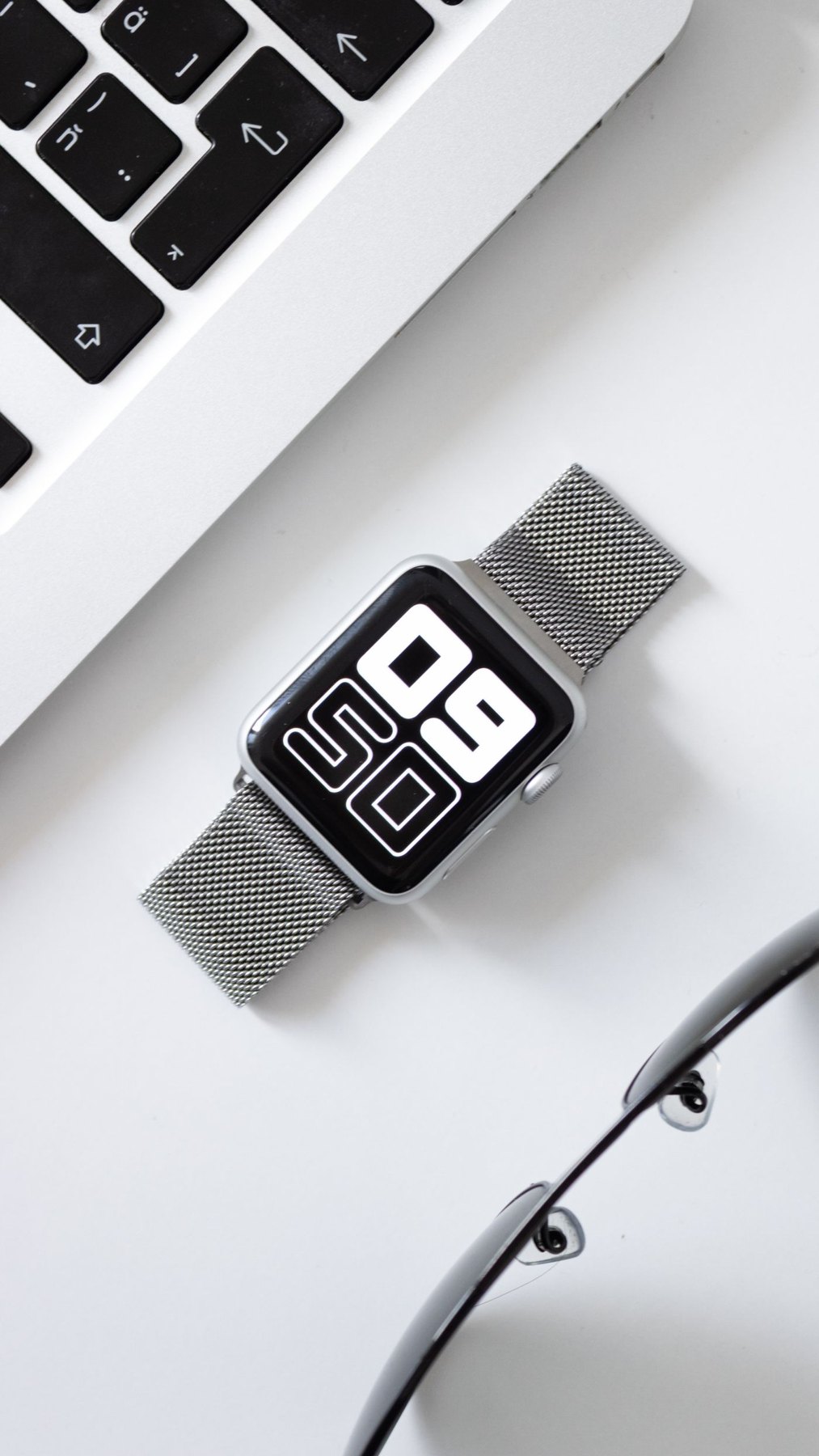 Smartwatch beside a laptop and other accessories